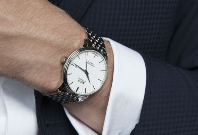 Dây đồng hồ Mido kim loại sang trọng phối với vest công sở.