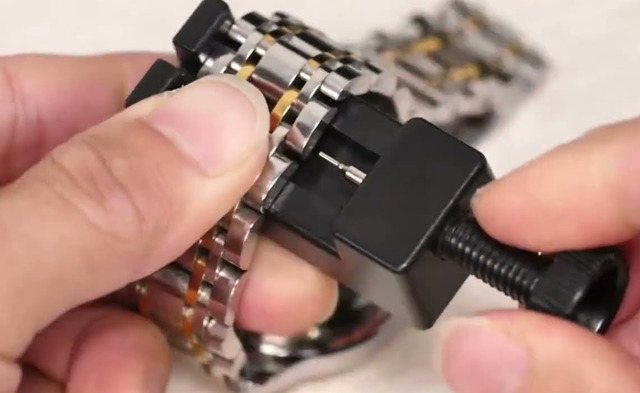 Kỹ thuật viên dùng dụng cụ chuyên dụng để thay dây đồng hồ Huawei.